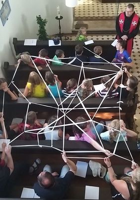 Beim abendlichen Gottesdienst knüpften die Kinder und Jugendlichen ein Netz aus Fixierbinden. Foto: E.Stegmaier/Malteser